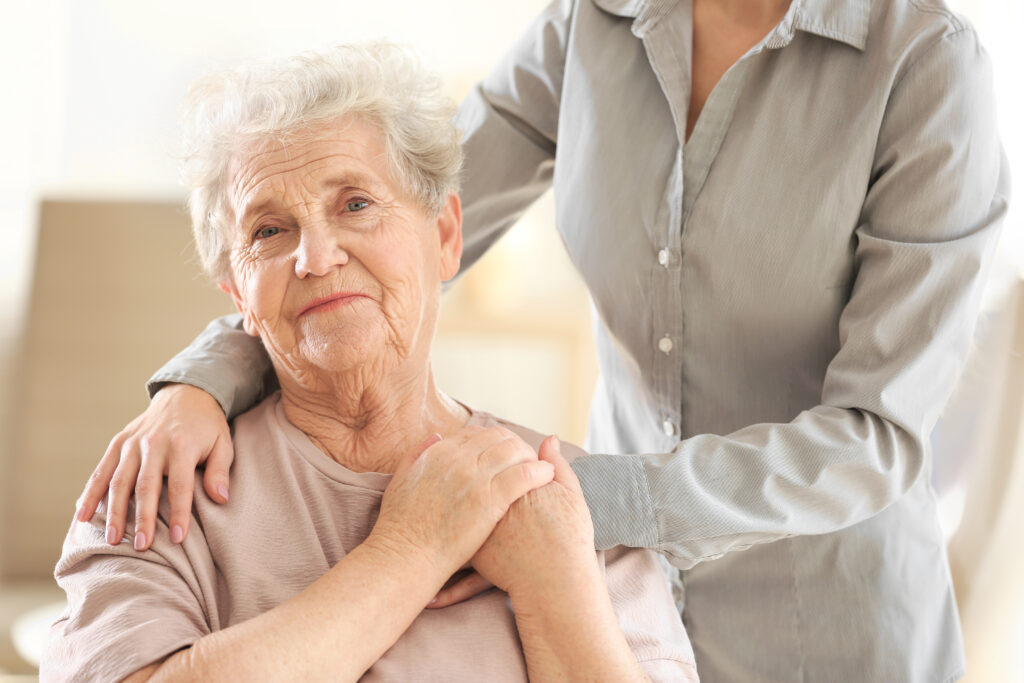 Ältere Dame wird von Betreuungskraft unterstützt, 24-Stunden-Pflege