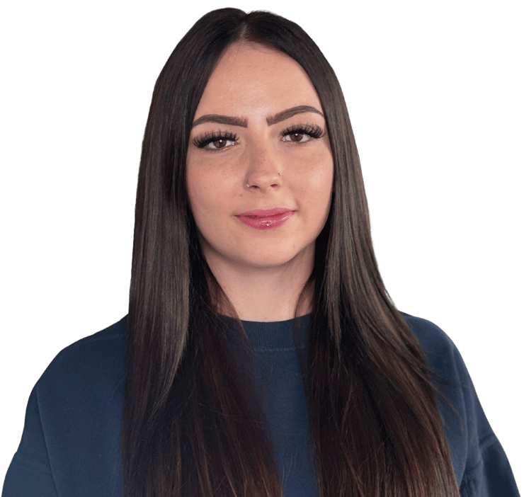 Patricia Wildermuth, mit langen glatten dunklen Haaren und einem marineblauen Oberteil, posiert vor einem schlichten weißen Hintergrund und schaut mit neutralem Blick direkt in die Kamera.