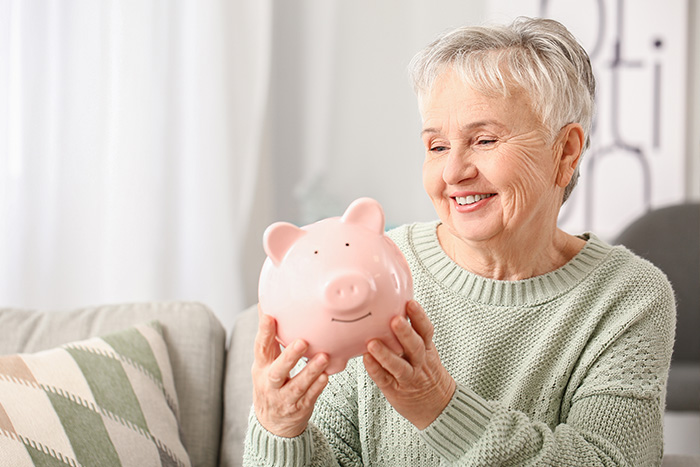 Eine Frau mit einem rosafarbenen Sparschwein als Symbol für Finanzplanung und Sicherheit - wichtige Themen in der Pflegeberatung nach § 37 Abs. 3 SGB XI.